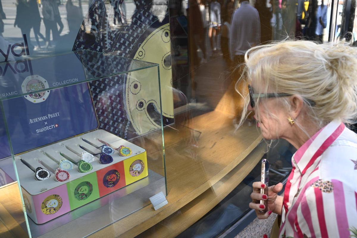 Cola de posibles compradores en el exterior de la tienda Swatch en Paseo de Gracia esquina Gran Vía, cerrada por motivos de seguridad según anuncia un cartel, a raíz de la venta del modelo Swatch creado en colaboración con la firma de relojes de lujo Audemars Piguet