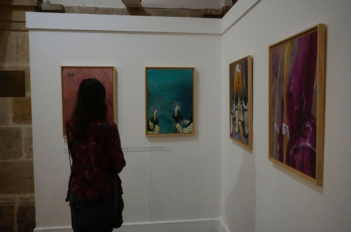 Una mujer contempla las pinturas de Teresa Álvarez. | J. L. F.