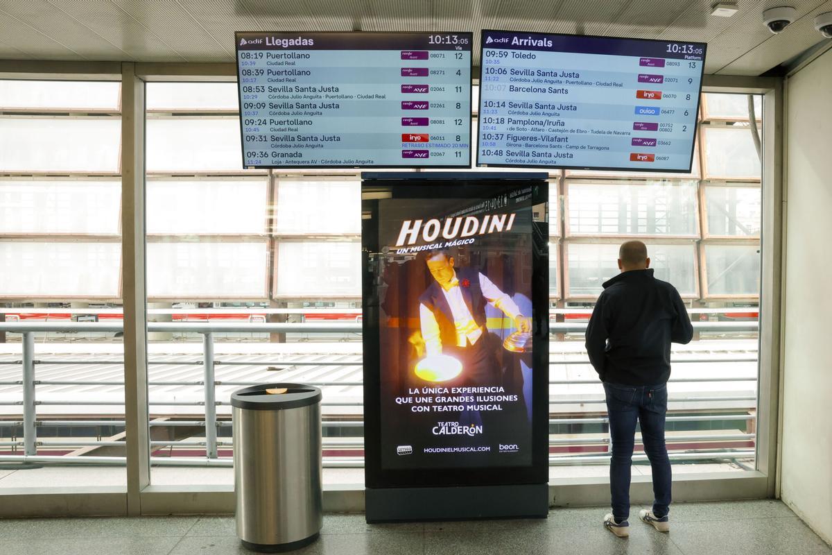 Un hombre junto a los paneles de llegada y salida de los trenes en la estación de Atocha.