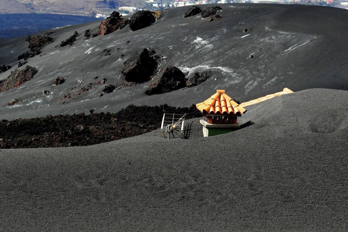 En la imagen de archivo, vivienda en Las Manchas completamente cubierta por la ceniza, con una colada de lava que brotó bajo sus cimientos. EFE/Elvira Urquijo Á.