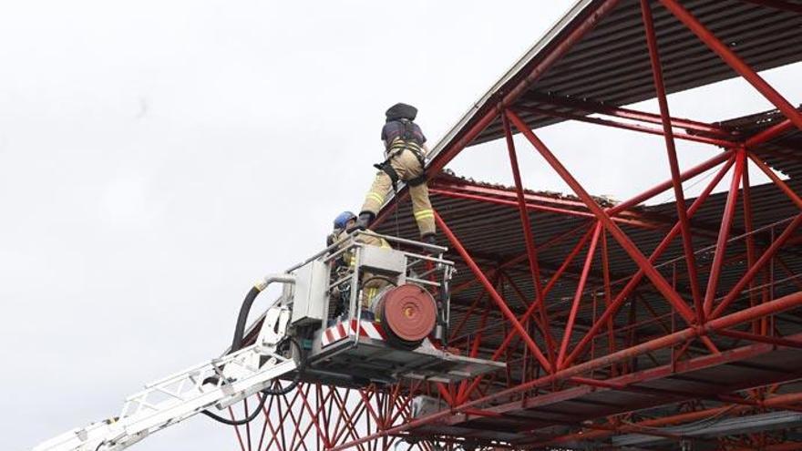 Bomberos reparan la cubierta de Río. // R. Grobas