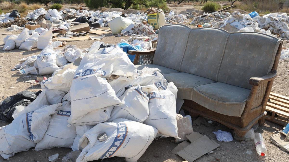Montañas de escombros, basura, enseres y material de obra que se acumulan día tras día en un solar junto a la avenida de Dénia.