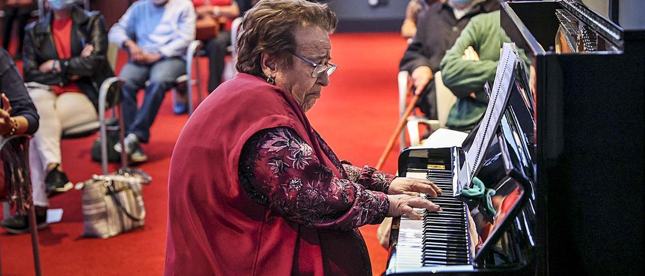 Purita de la Riva, al piano, en el Club Prensa Asturiana. | Irma Collín