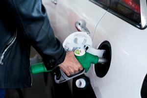 Una mujer pone gasolina a su vehículo en una gasolinera, a 17 de junio, en Madrid.