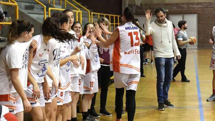 Las jugadoras del Maristas, junto a su entrenador Fernando Buendía, se saludan y animan antes de un partido.