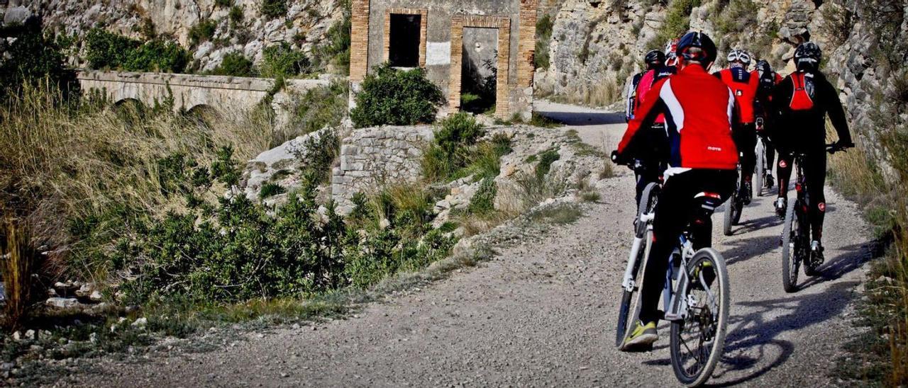 Ciclistas en el antiguo trazado ferroviario de Alcoy a Gandia, en el tramo de l’Orxa a Villalonga. | JUANI RUZ