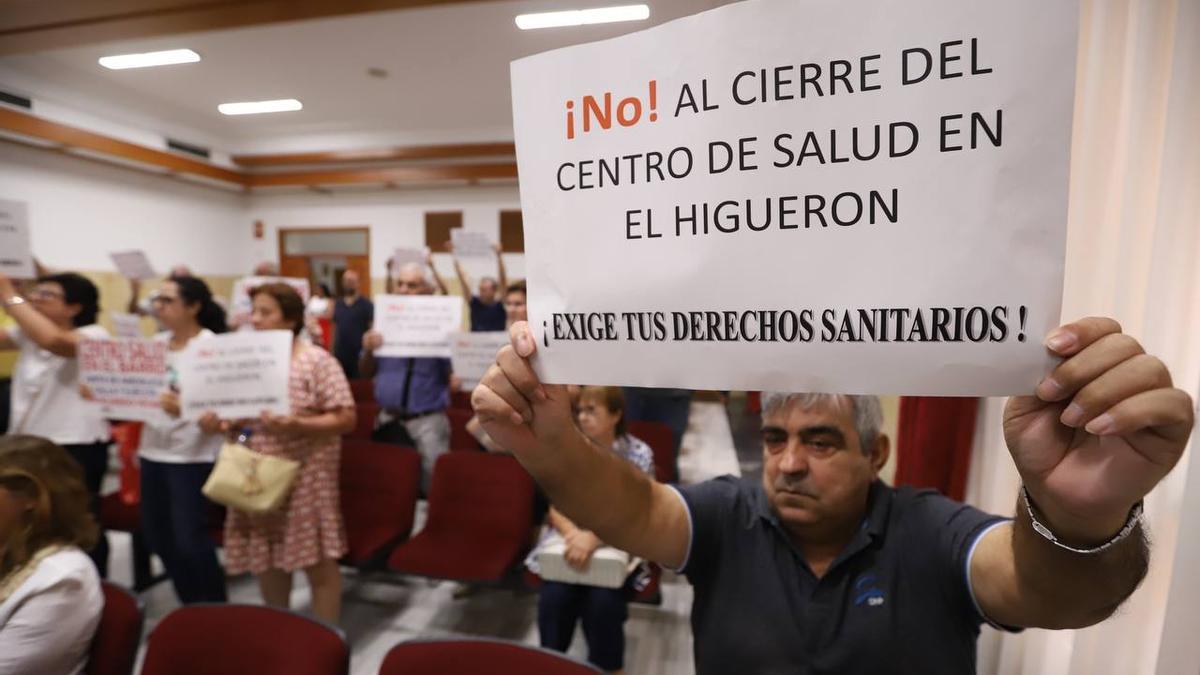 Un vecino de El Higuerón, en el salón de plenos, con una pancarta de protesta.