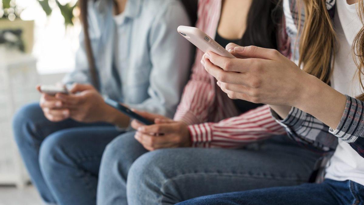 Personas utilizando sus teléfonos inteligentes.