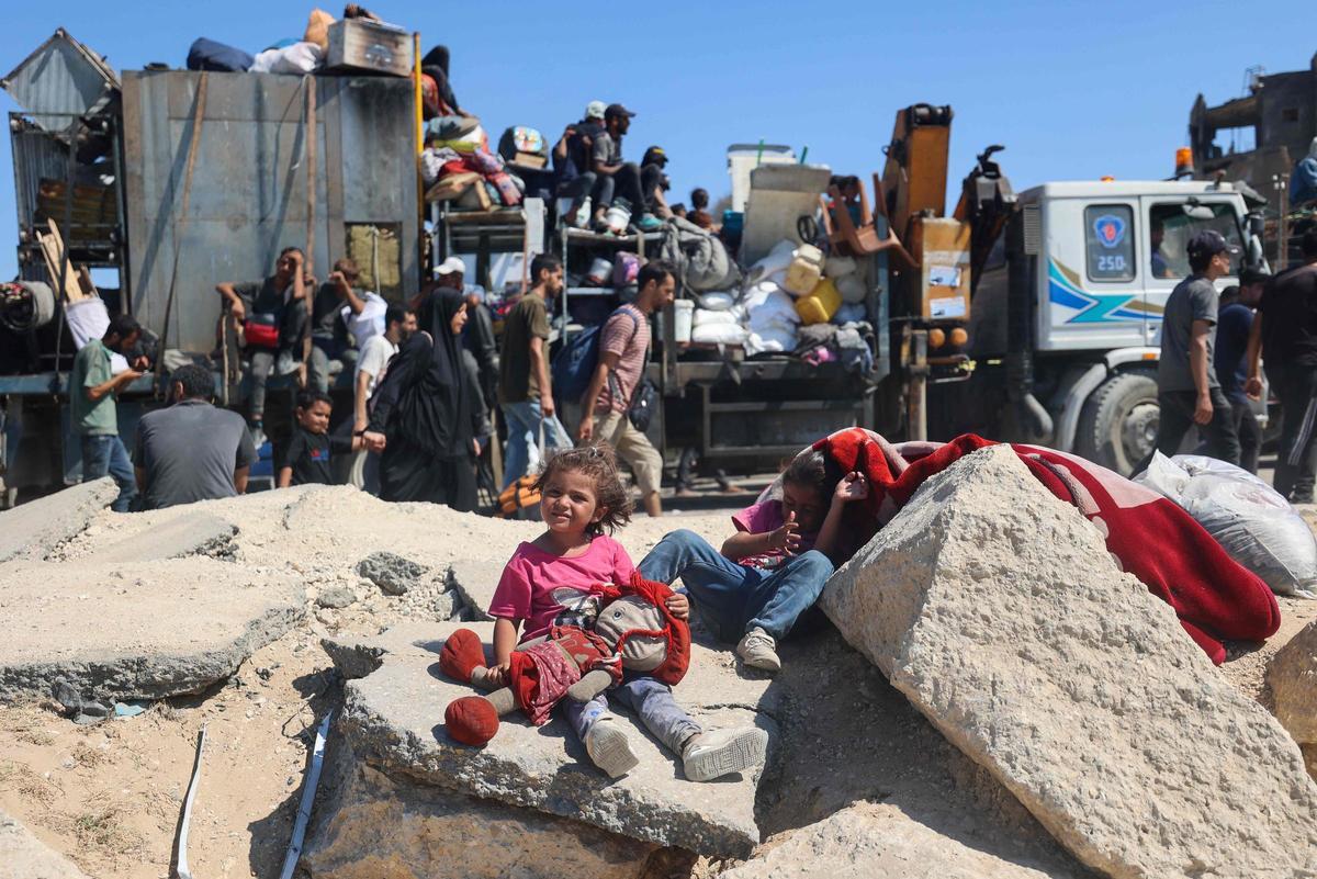 Palestinos desplazados se trasladan hacia el sur con sus pertenencias por una carretera en la zona del campo de refugiados de Nuseirat, en el centro de la Franja de Gaza.