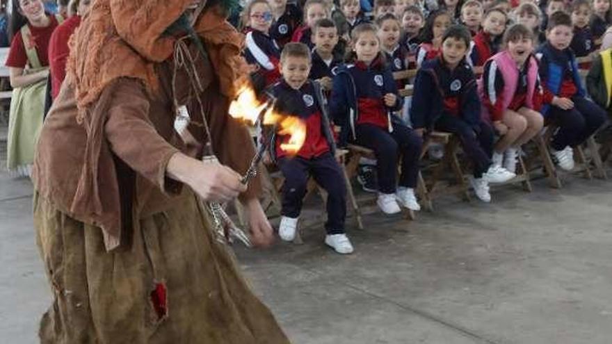 Los niños participantes observan con asombro una de las representaciones de mitología asturiana.