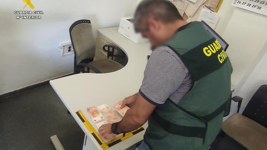 Un agente de la Guardia Civil muestra el dinero falso que ha sido incautado en Santa Pola.