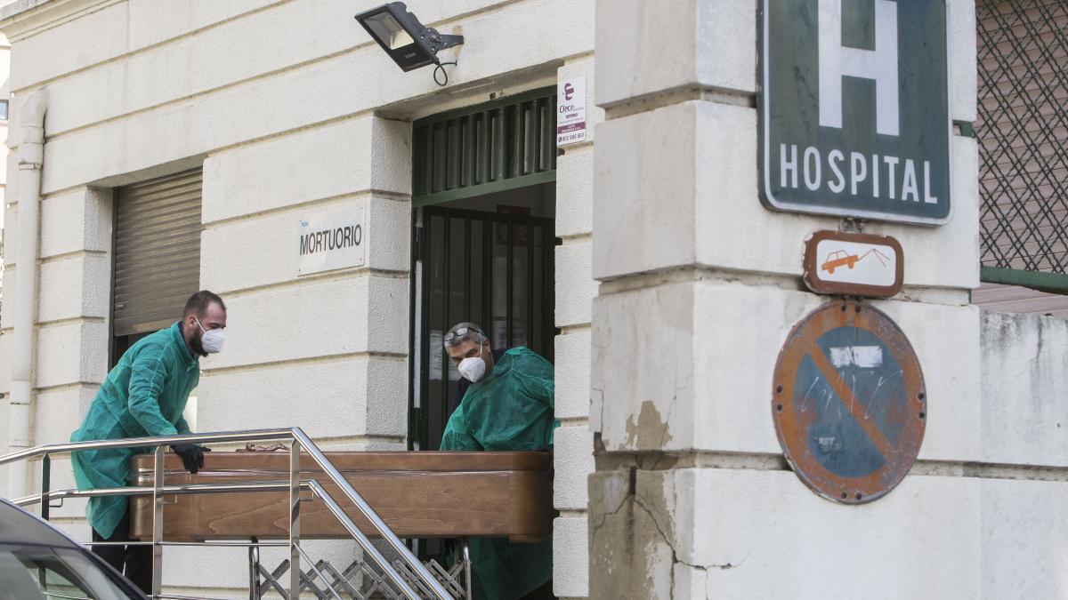 Dos trabajadores sacando un féretro de un fallecido por covid del mortuorio del H. General en lo peor de la ola de 2021.