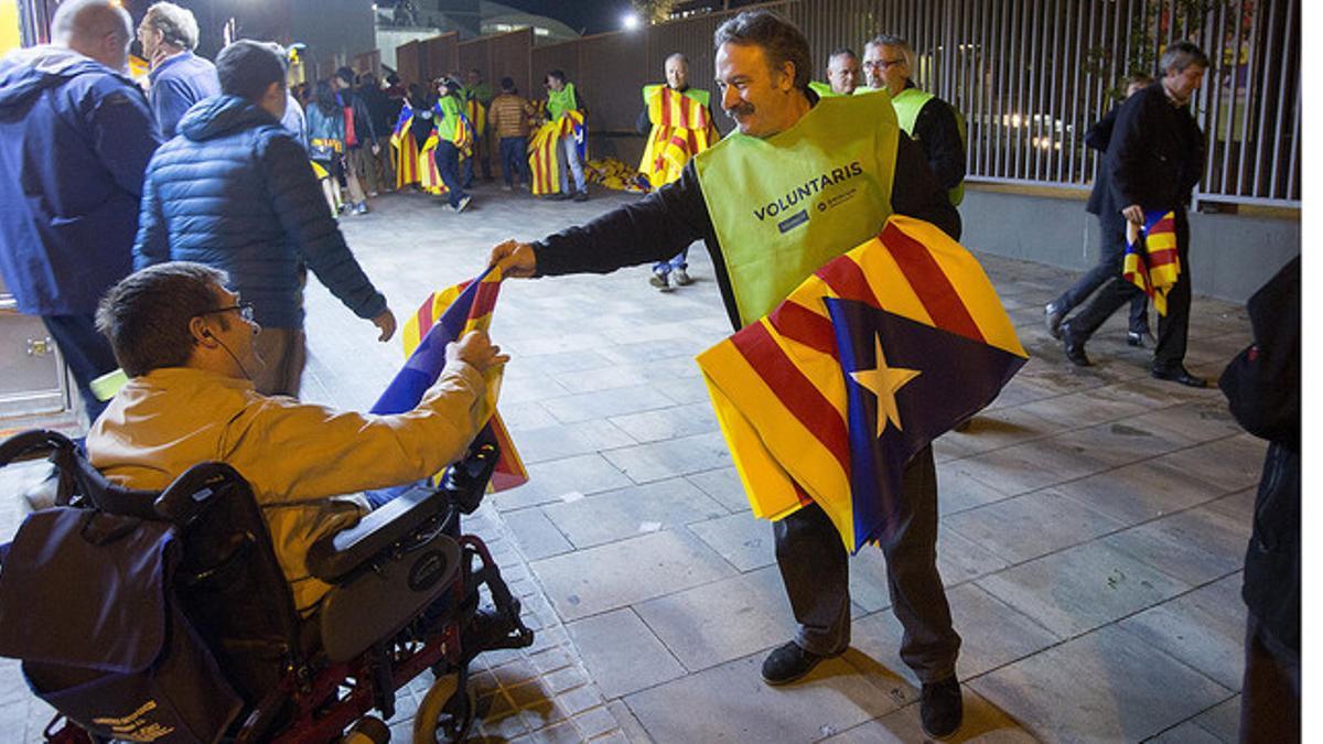 Un voluntario reparte estelades a las puertas del Camp Nou, antes del Barça-Bate