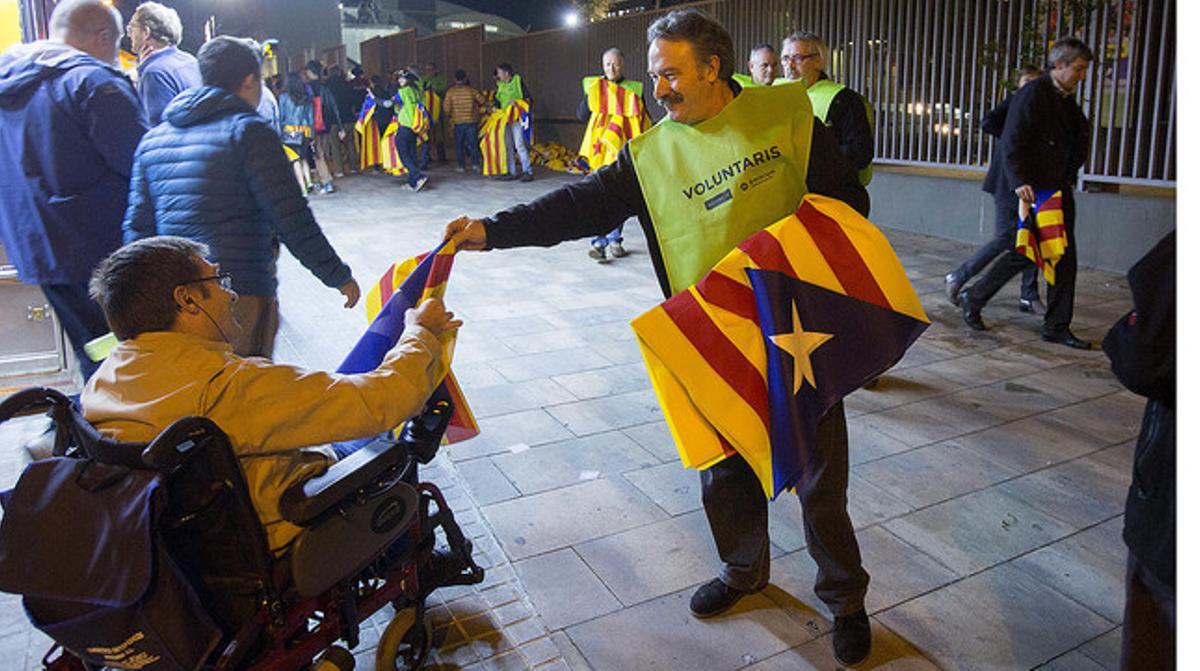 Un voluntari reparteix estelades a les portes del Camp Nou, abans del Barça-Bate.