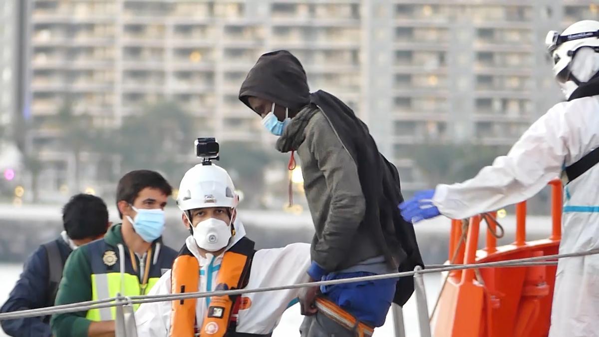 Un miembro de la Cruz Roja ayuda a bajar del barco a un hombre migrante en el puerto de Arguineguín, en Gran Canaria (recurso)