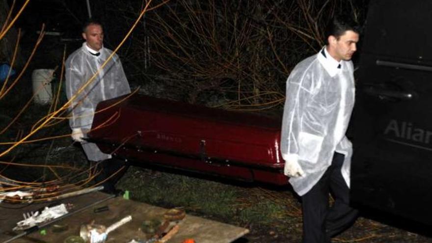 Trabajadores de la funeraria trasladan el cadáver en un ataúd. // Carmen Giménez