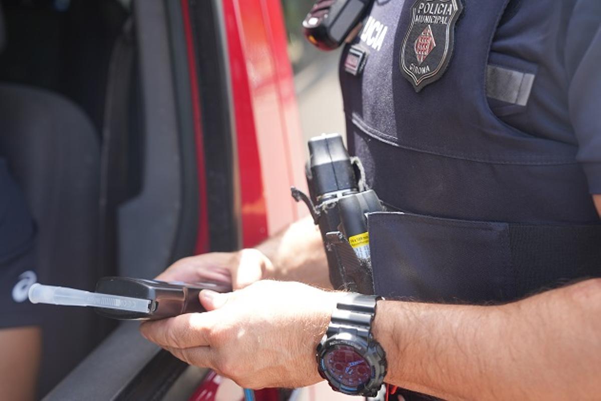 Un agent de la Policia Municipal de Girona amb l'alcoholímetre per fer la prova.