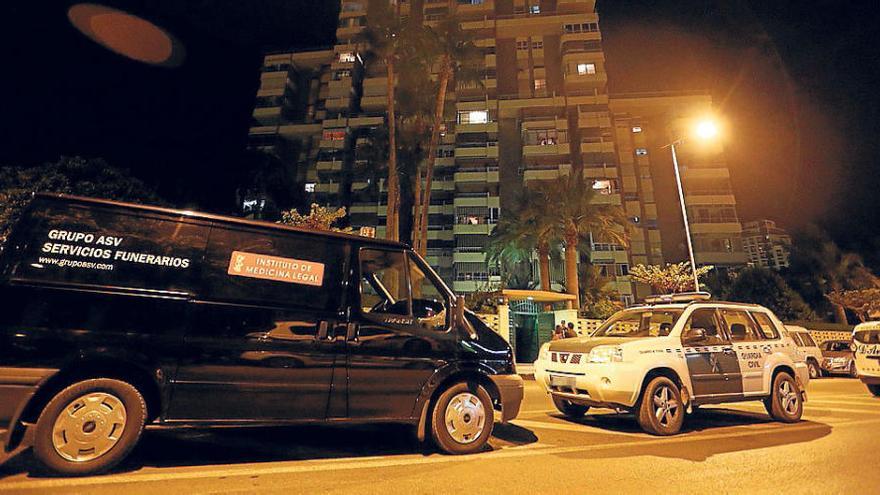 Un furgón de los servicios funerarios y coches de la Policía anoche a las puertas de la vivienda