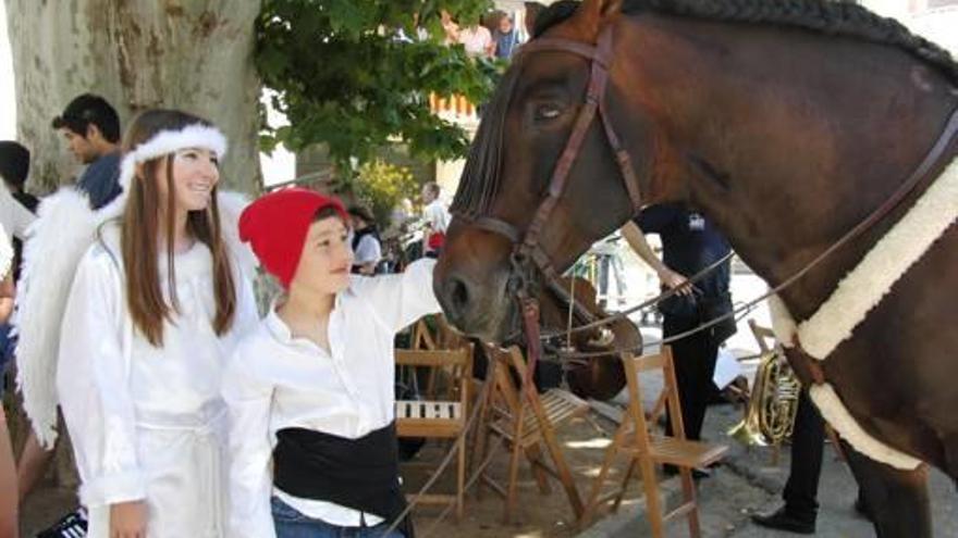 Dos infants acaricien un cavall a la Festa de Sant Isidre.