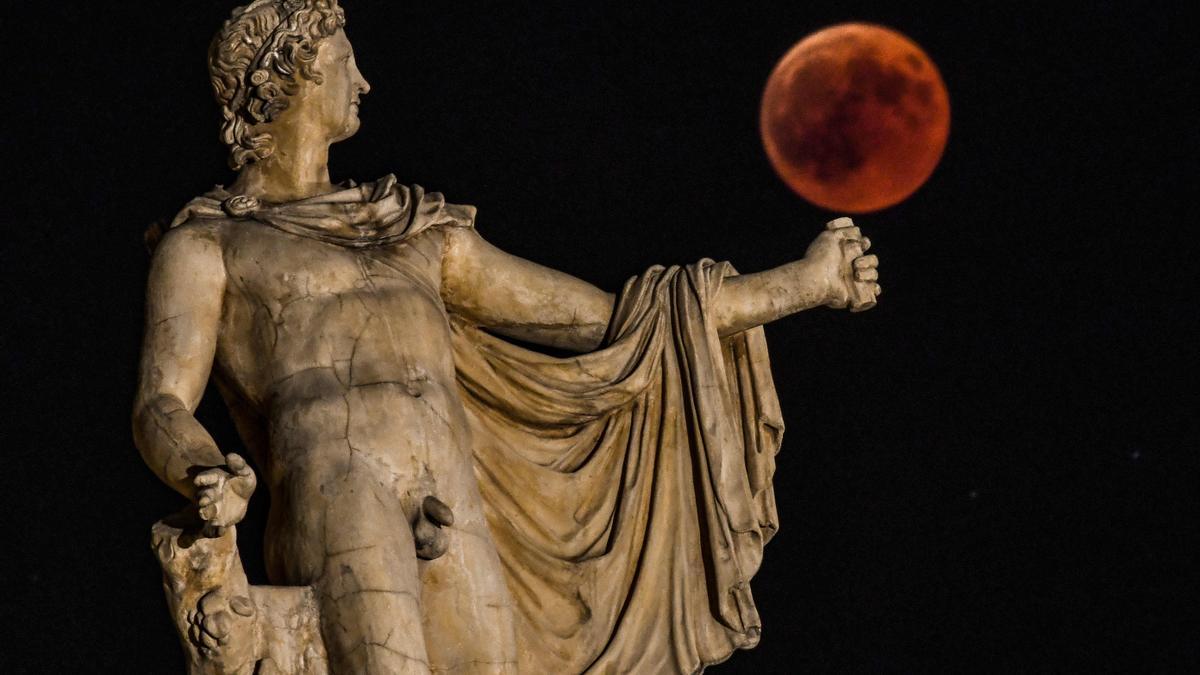 Fotografía de la 'luna de sangre' del 2018 en Atenas, junto a una estatua de la antigua Grecia del dios Apolo.