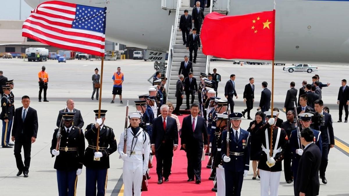 El presidente de China, Xi Jinping, camina junto al secretario de Estado Rex Tillerson a su llegada al aeropuerto internacional de Palm Beach de Florida.