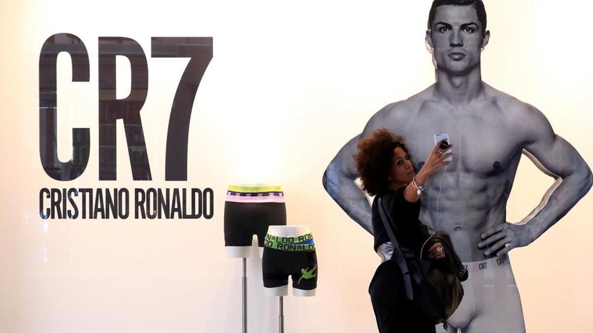 Una mujer se hace un selfie ante un anuncio de Cristiano Ronaldo en Milan.
