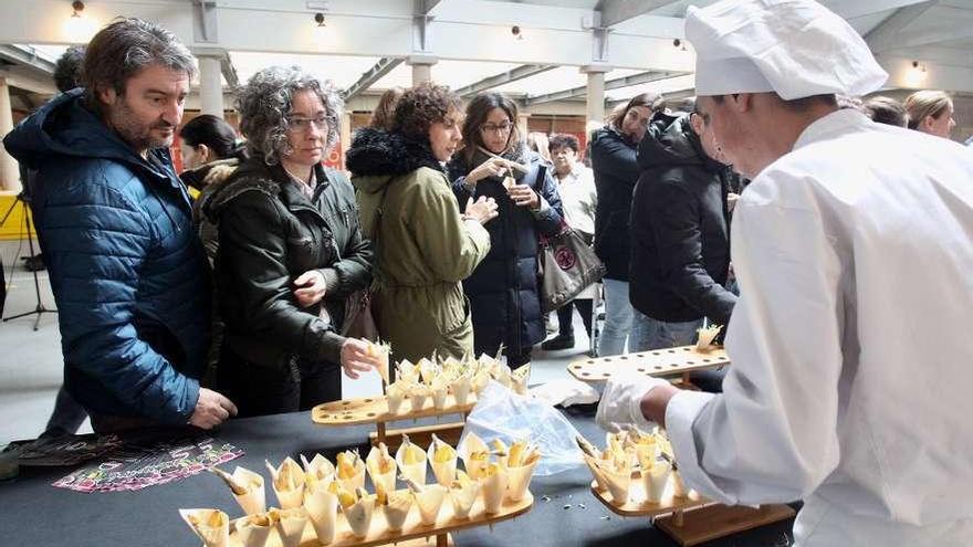 Los clientes del Mercado probaron los pinchos elaborados por los alumnos del Carlos Oroza. // R.V.