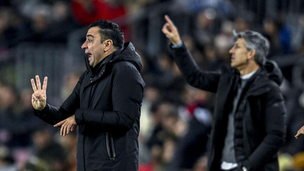 Xavi, con Imanol al fondo, da instrucciones a sus jugadores en el partido contra la Real.