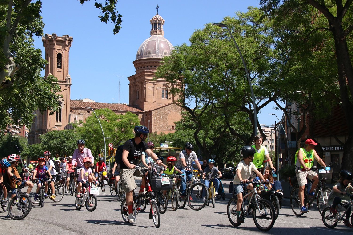 El paso de las bicicletas este domingo por delante de la parroquia de Sant Andreu de Palomar.