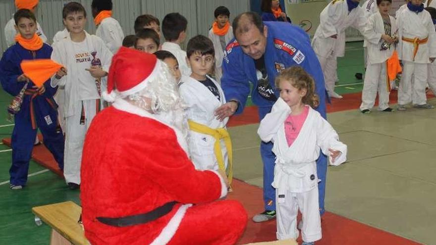 Una joven judoka sonríe al conocer a Papá Noel.