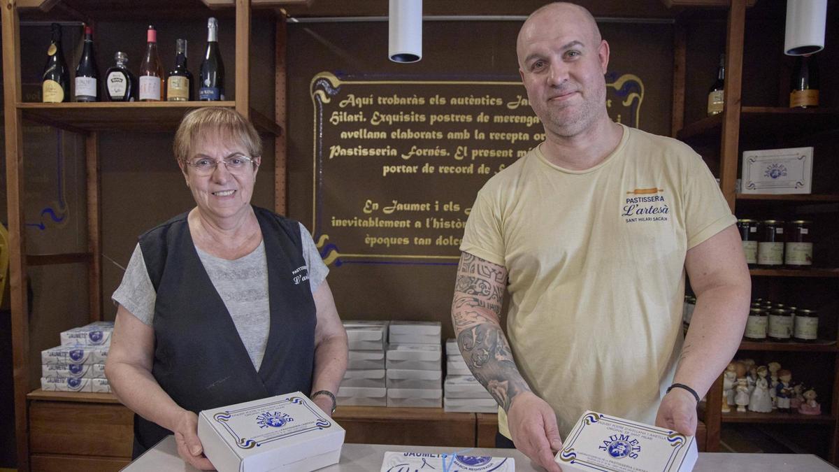 El pastisser Jordi Mosoll i la seva mare, Maria Teresa Vernedas, amb capses de jaumets a la pastisseria l’Artesà, a Sant Hilari Sacalm.