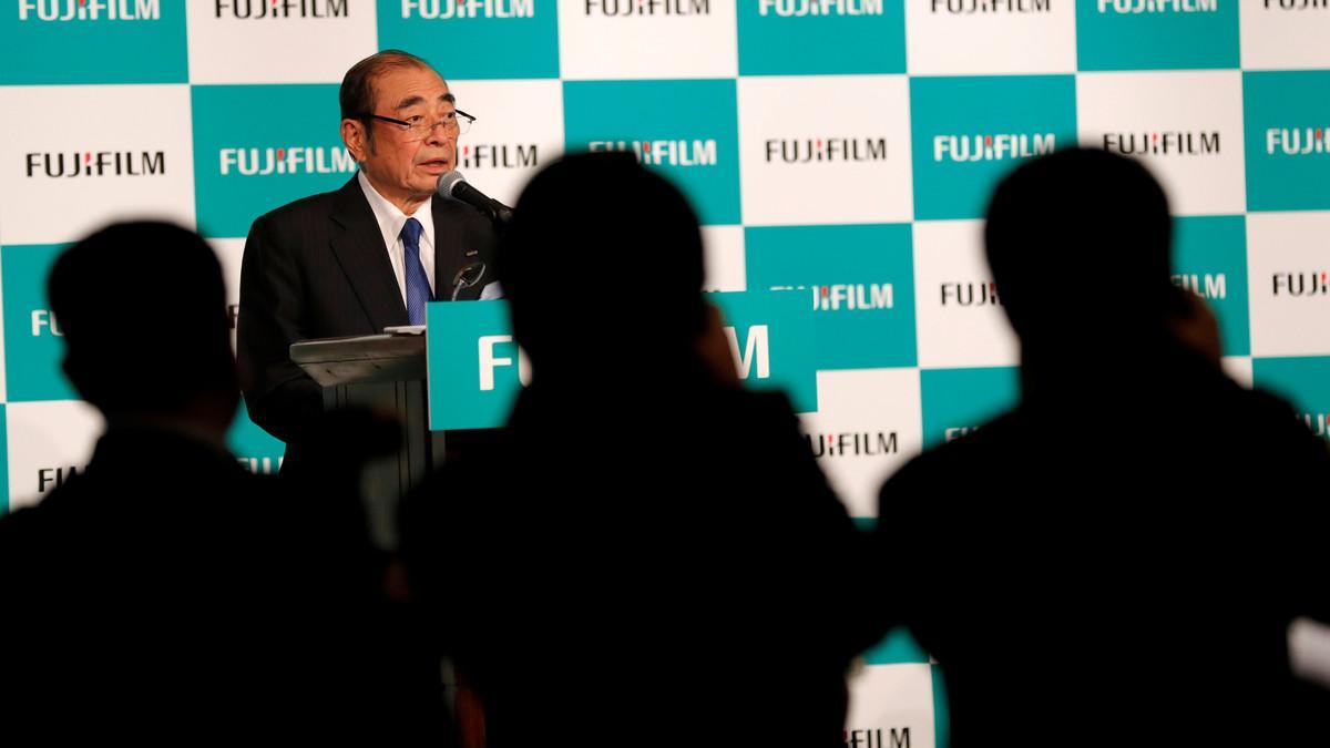 Photographers take pictures of Fujifilm Holdings' Chief Executive Officer Shigetaka Komori who is speaking at a news conference in Tokyo