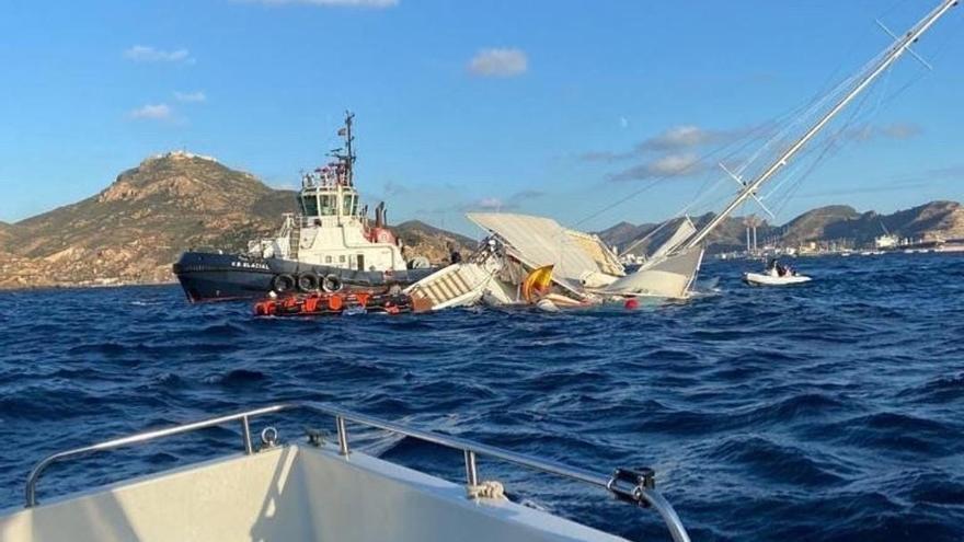 Un buque de Sasemar remolca el catamarán hundido en la costa de Cartagena.