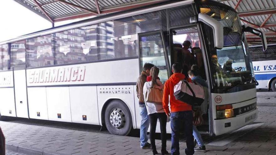 Varias personas suben al autobús.