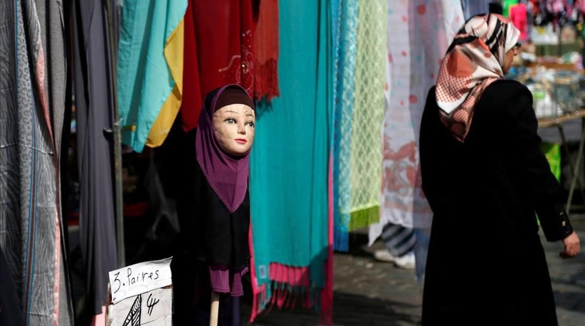 Una mujer musulmana pasa junto a una tienda de venta de pañuelos islámicos en Bruselas.