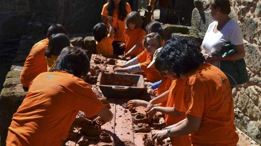 Un grupo de niños participa en las manualidades con el adobe.