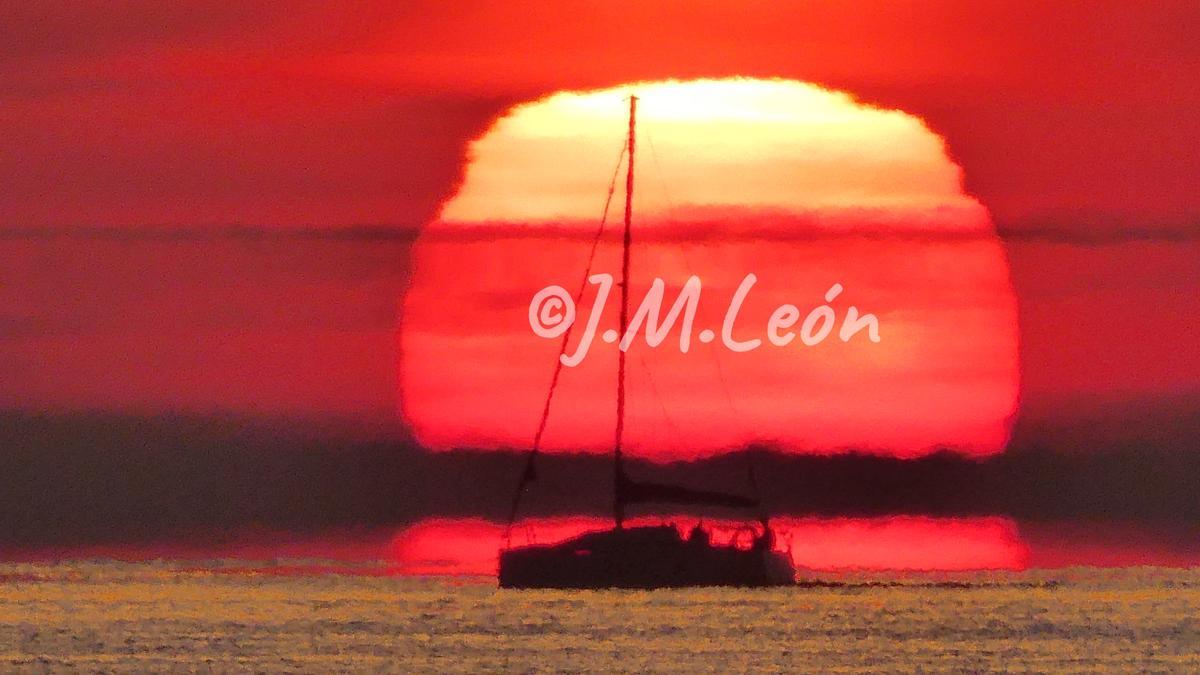 Fotografía de un velero en un amanecer en la Playa de la Malvarrosa de València.