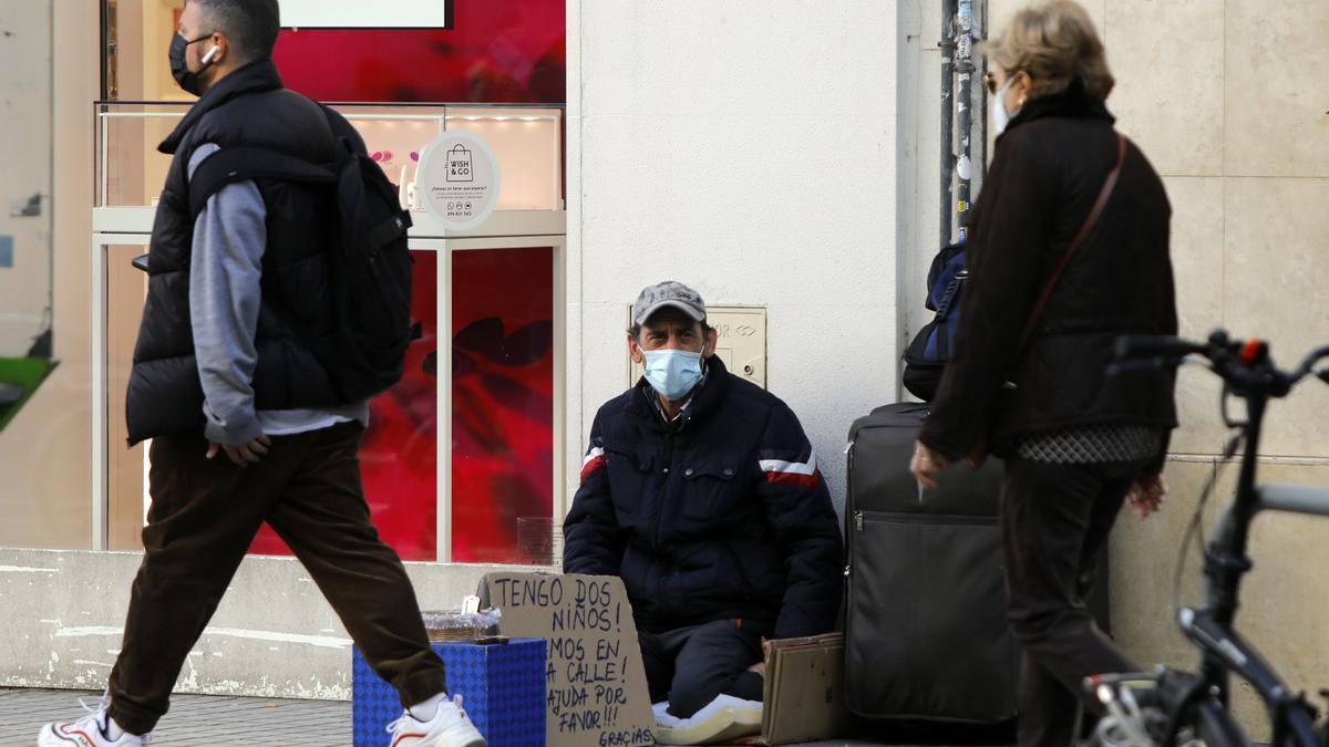 Un home demana almoina al carrer a València, en una imatge d’arxiu