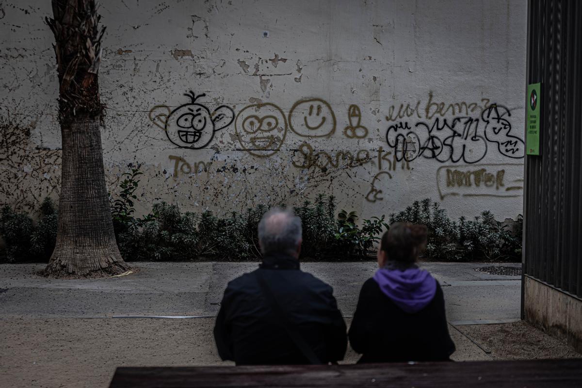 Una pareja  contempla una de las paredes del jardín, que desde luego vivió mejores tiempos.