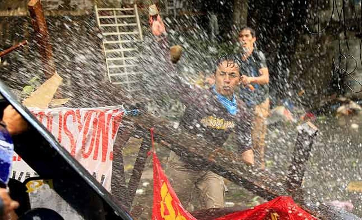 Filipins s’armen amb ampolles i pedres per enfrontar-se a l’equip encarregat de la demolició d’un conjunt de barraques per a la construcció d’un edifici oficial a San Juan City, a l’est de Manila (Filipines).