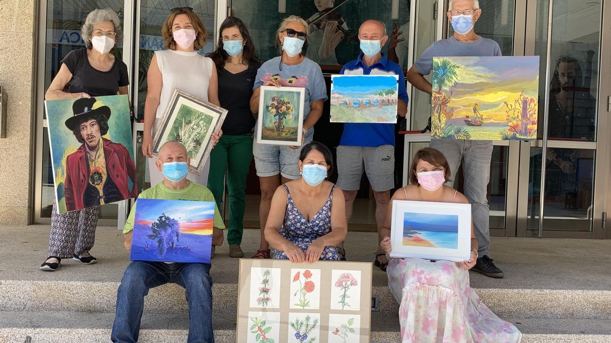 Alumnos de la Escola Municipal de Pintura de Nigrán, con sus cuadros.