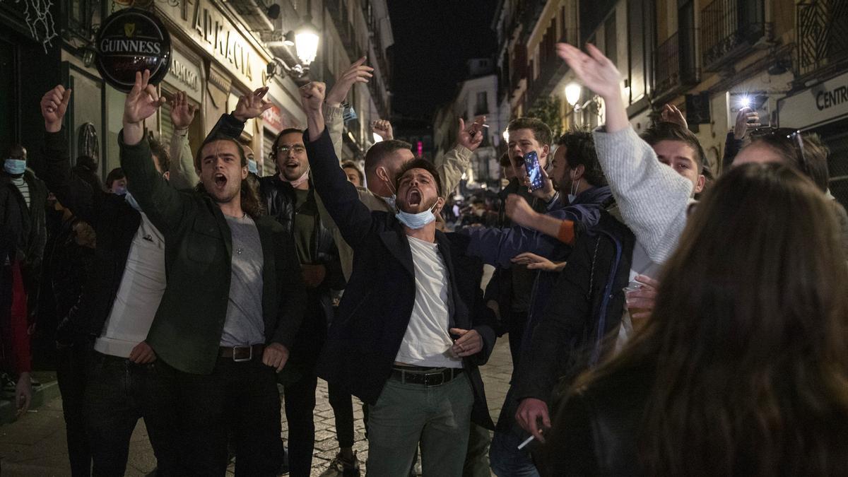 MADRID, SPAIN - MARCH 20: Tourists sing outside a bar as the curfew starts during the Coronavirus pandemic on March 20, 2021 in Madrid, Spain. Whilst Covid-19 infection figures remain high, the Spanish capital of Madrid has relatively relaxed restrictions with bars and restaurants open since late 2020 - compared to Italy, France and the rest of Spain. Madrid's economy grew by 4.4 per cent in the last quarter of 2020, creating one out of three jobs in Spain. (Photo by Pablo Blazquez Dominguez/Getty Images)