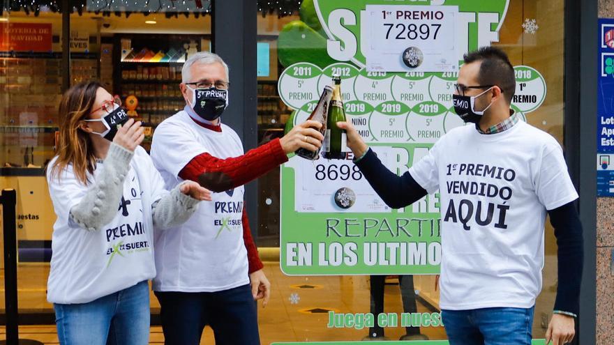 Tres loteros brindan con champán en una administración gallega.