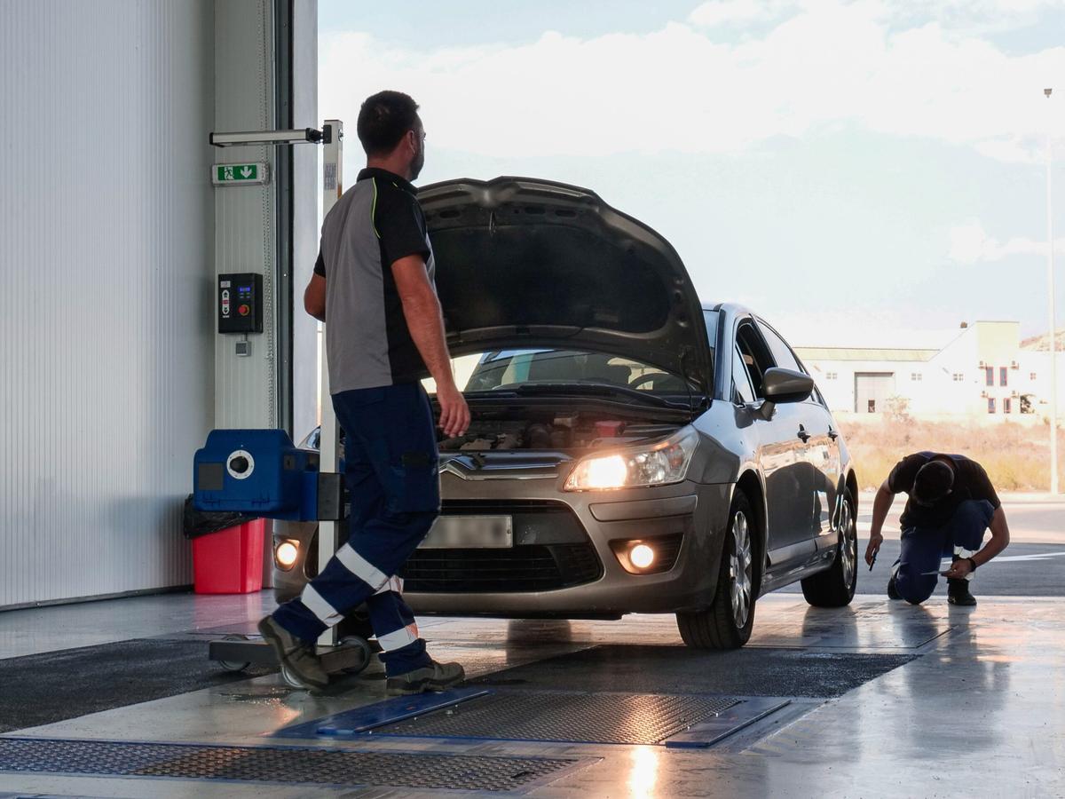 Un trabajador de una ITV del municipio de La Unión comprueba el motor de un vehículo durante una inspección técnica.