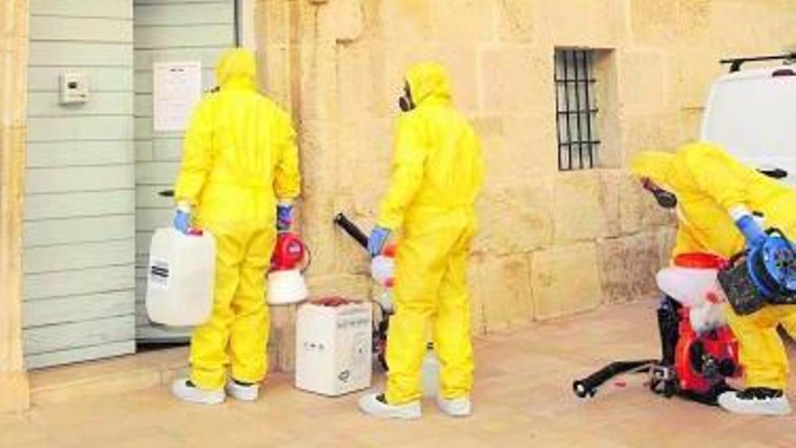 Trabajadores de Laboratorios Lokímica desinfectan el Santuario y el Monasterio, y, a la derecha, el ecónomo durante una misa en Aspe. | MANUEL R. SALA/INFORMACIÓN