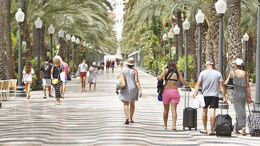 Grupo de turistas en Elche, ciudad que se libra del toque de queda, y con maletas por el Paseo de la Explanada de Alicante