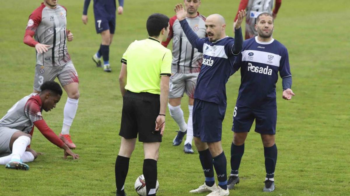 Luis Morán y Lora, del Marino, protestan al colegiado Ruiz Rabanal durante el derbi ante el Avilés, ayer en Miramar. | Ricardo Solís