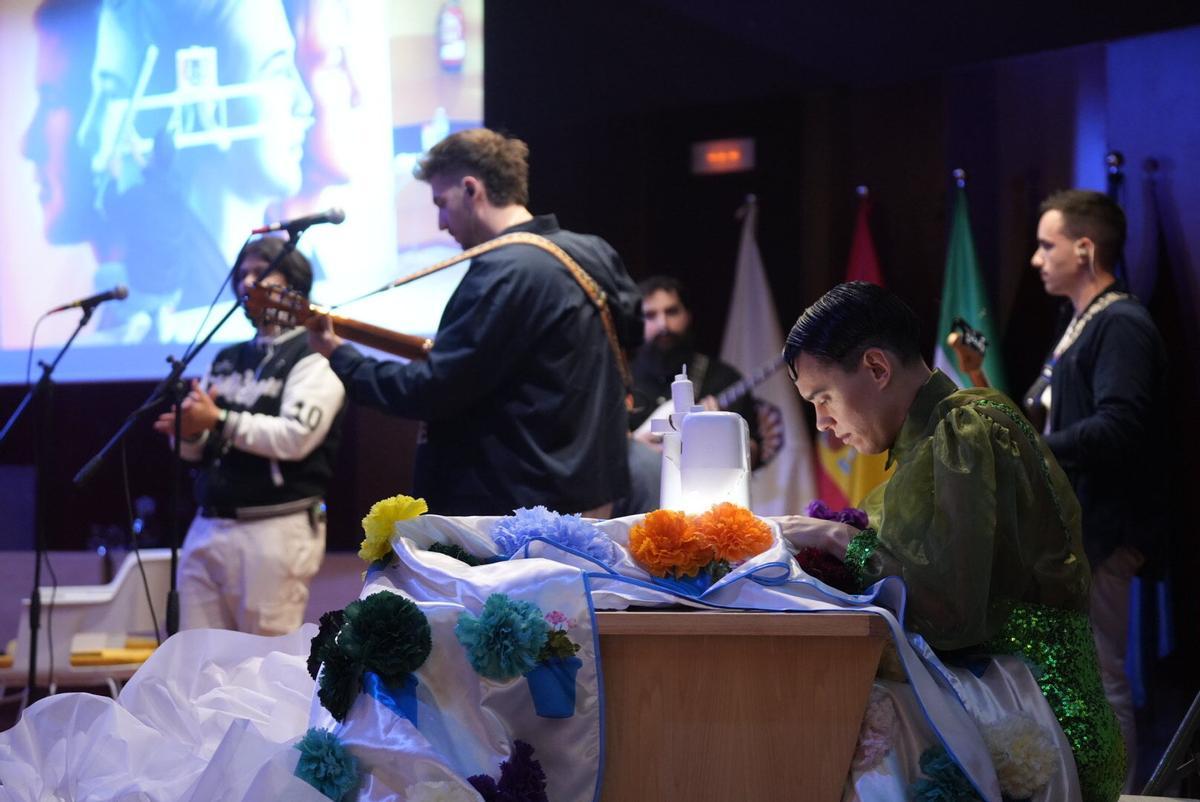 El diseñador José Perea confecciona su traje mientras canta el grupo Carril Bici.