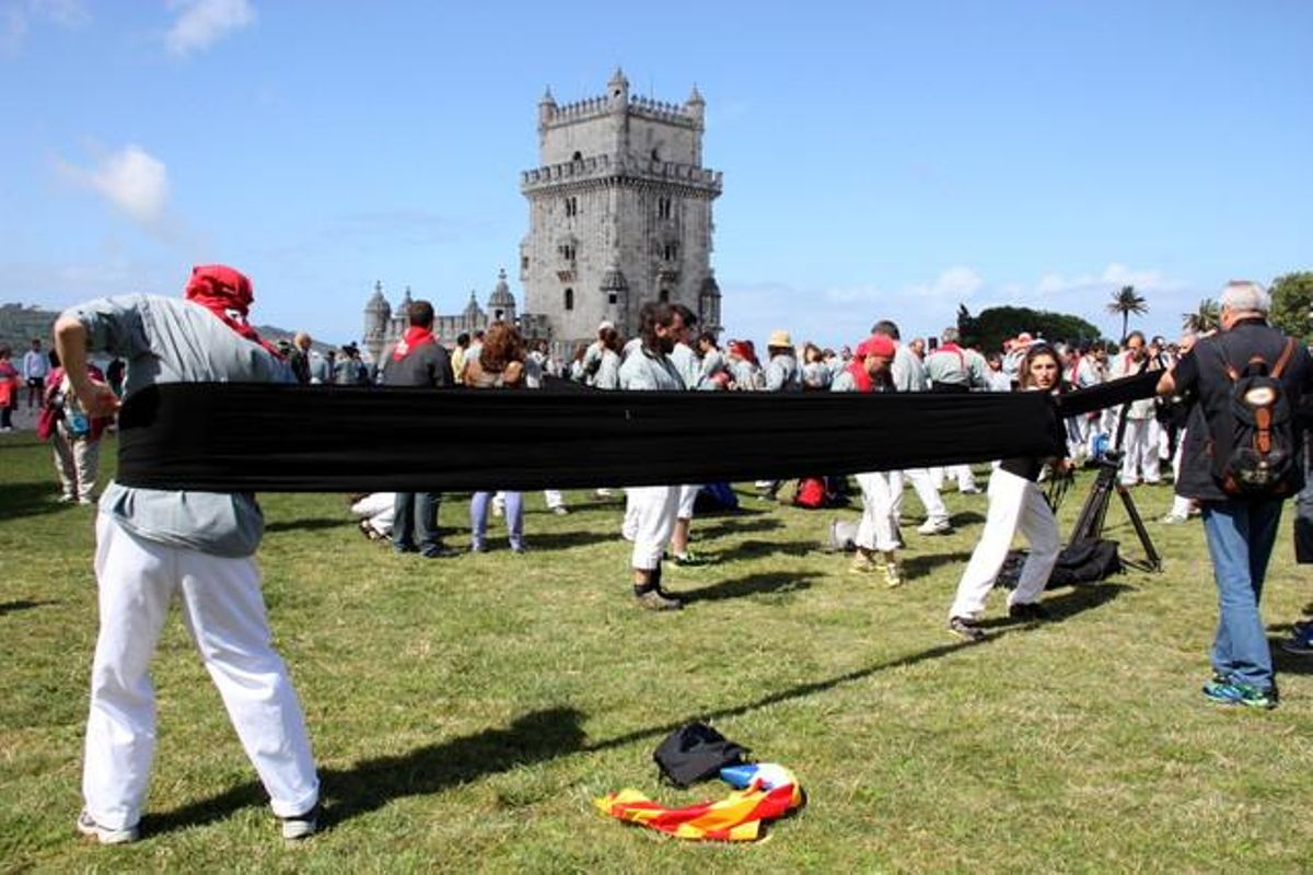 Els Castellers de Sants enfaixant-se per a un 3 de 9 davant de la Torre de Belém de Lisboa.