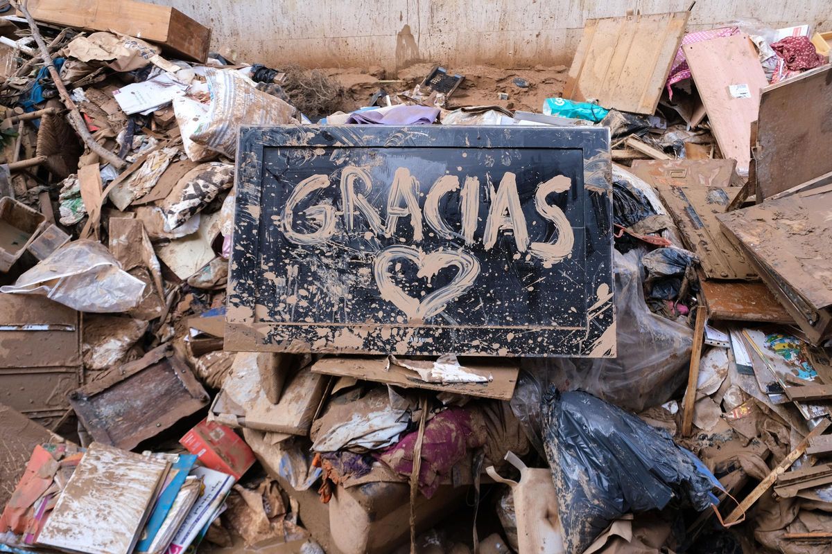 Escombros generados por la dana de Valencia y una "pintada" en barro esperanzadora y agradecida